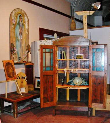 A spanish style wooden cabinet called a trastero with doors open to reveal beautiful interior with folding shelf that converts to desk.